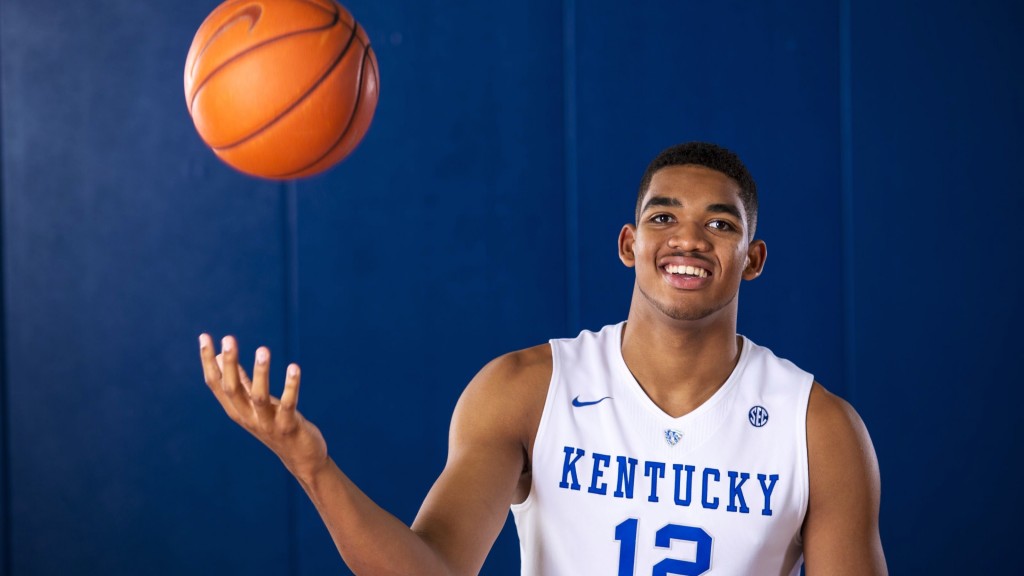 basketball player Karl-Anthony Towns smiling and throwing basketball in the air