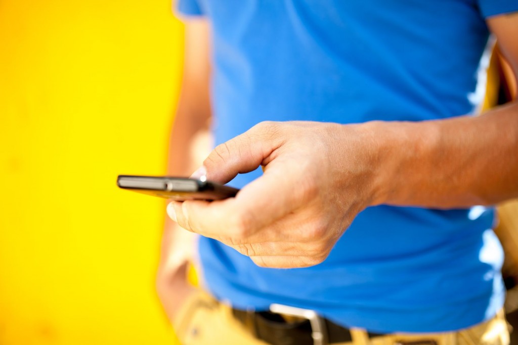 man with phone on yellow background