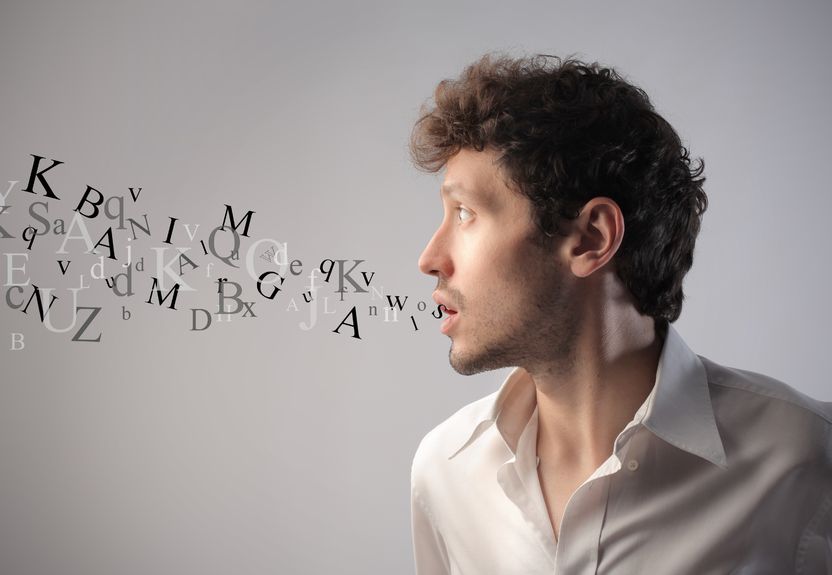 Young man talking with alphabet letters coming out of his mouth