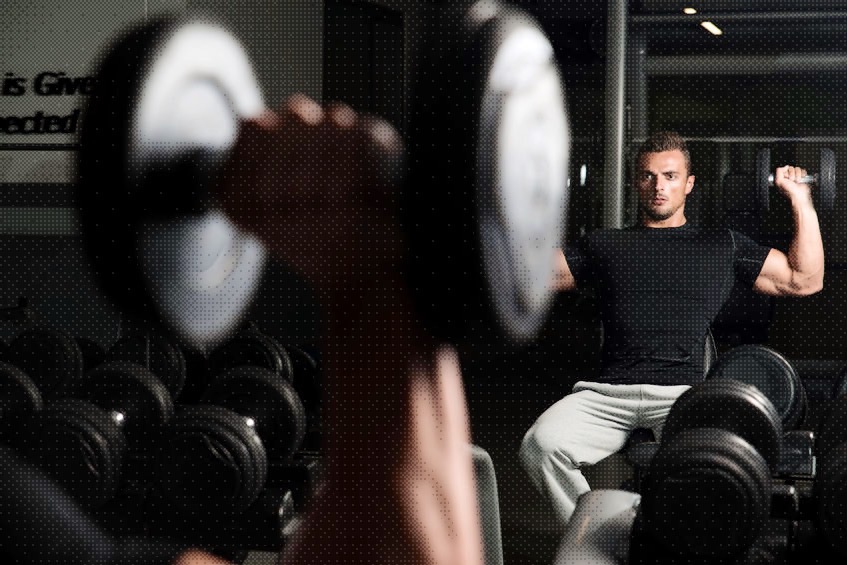 man completing Shoulder Press Exercise at gym edited