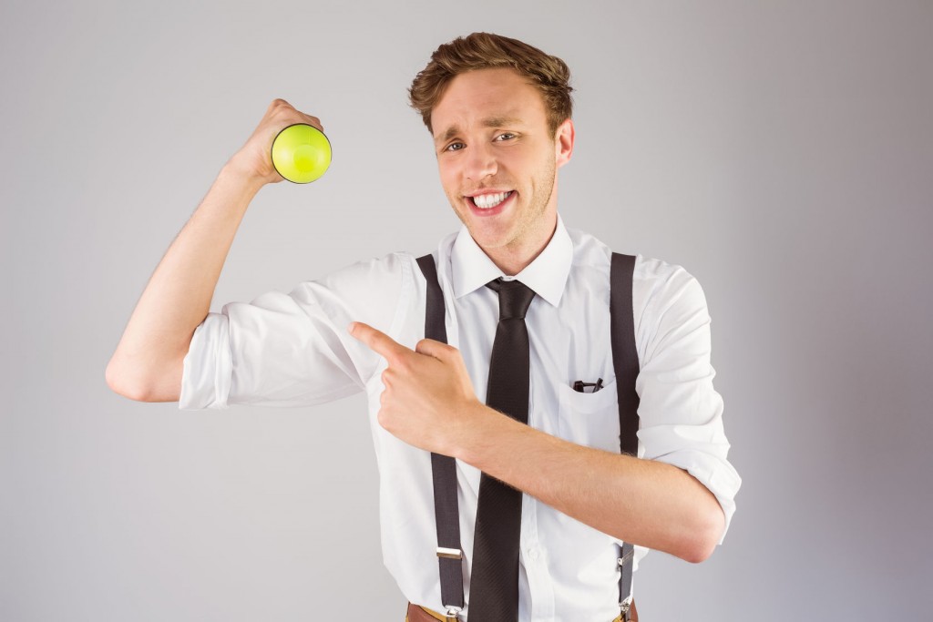 Geeky businessman lifting a dumbbell on grey background