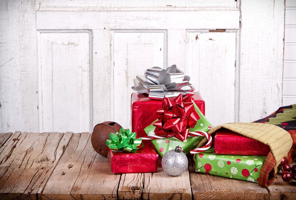 Christmas presents spilling out of a stocking on wooden plank with antique door panel background