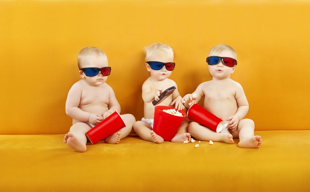 three babies wearing 3d glasses and holding popcorn buckets